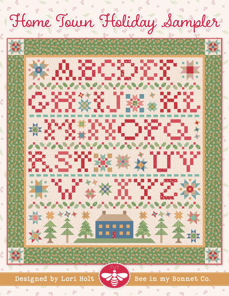 Image of the It's Sew Emma Home Town Sampler Quilt Pattern by Lori Holt for Riley Blake Designs. Features a quilt with the alphabet and a green border. 
Cute Little Fabric Shop