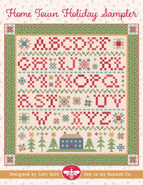 Image of the It's Sew Emma Home Town Sampler Quilt Pattern by Lori Holt for Riley Blake Designs. Features a quilt with the alphabet and a green border. 
Cute Little Fabric Shop
