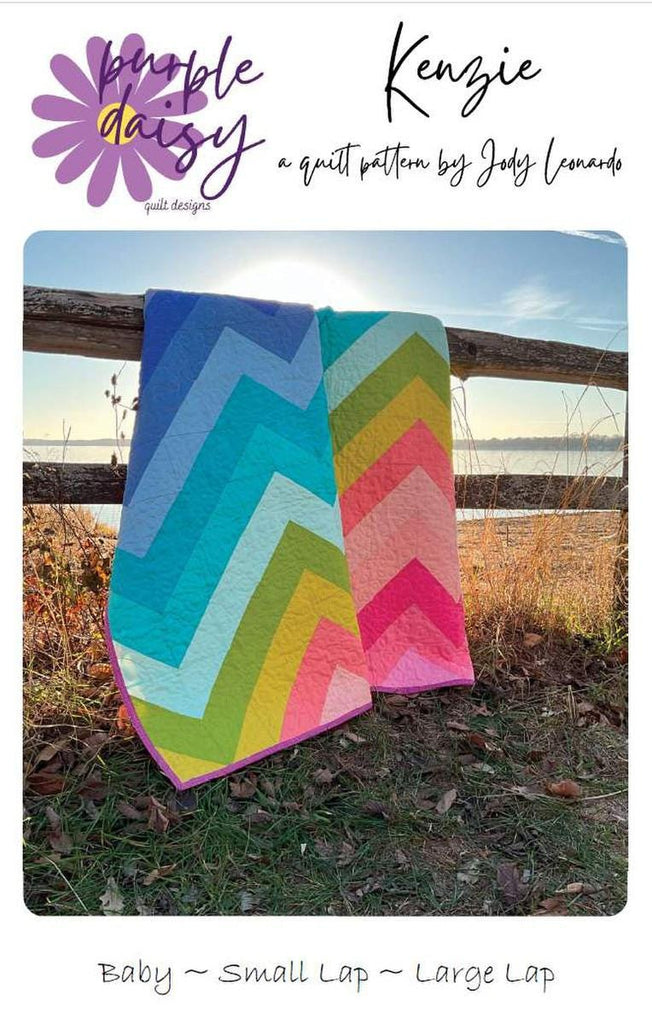 Image of the Kenzie Quilt Pattern by Purple Daisy Quilt Designs for Riley Blake Designs. Features half square triangles that create a rainbow of elongated chevron stripes. 
Cute Little Fabric Shop