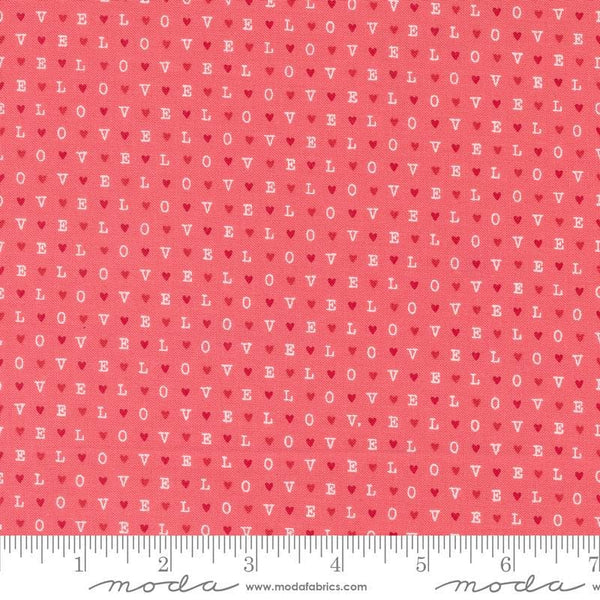 Image of the Love Blooms LOVE Lipstick quilting cotton fabric by Moda Fabrics. Features the word LOVE on a pink background. Cute Little Fabric Shop
