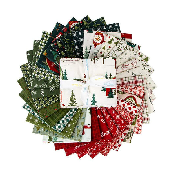 Image of Christmas Is in Town Fat Quarter Bundle by Riley Blake Designs. Features a cream fabric with trees, cabins, people, and snow, with other green, red, and cream fabrics scattered around. 
Cute Little Fabric Shop