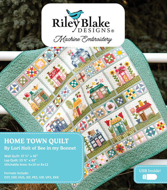 Picture of the Riley Blake Designs Machine Embroidery Home Town Quilt Projects. Pictures a quilt with embroidered houses and states that the USB is inside. 
Cute Little Fabric Shop