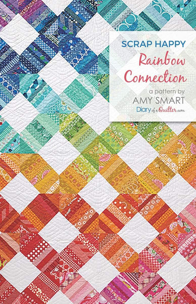 Image of the Scrap Happy Rainbow Connection quilt pattern by Amy Smart for Riley Blake Designs. Features a rainbow colored quilt pattern with X shapes and white squares. 
Cute Little Fabric Shop