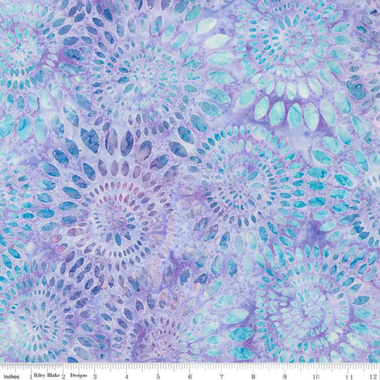 Image of the Wide Back Expressions Batiks Dahlias Wisteria Skye Riley Blake Designs quilting cotton fabric. Features swirls of blue on a light purple color. 
Cute Little Fabric Shop