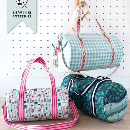 Image of the Melissa Mortenson Saturday Duffle Bag Pattern. Features a round, lined zippered duffle bag with an optional exterior pocket and a detachable shoulder strap. 
Cute Little Fabric Shop