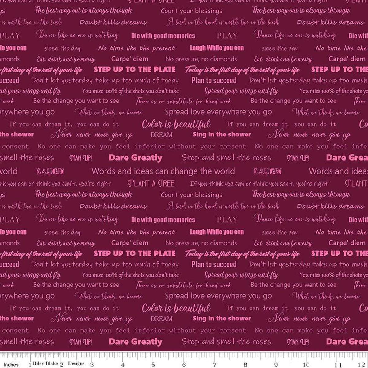 Image of the Fragrant Fields Script Maroon quilting cotton fabric by Lila Tueller for Riley Blake Designs. Features positive phrases on a dark pink purple background. 
Cute Little Fabric Shop