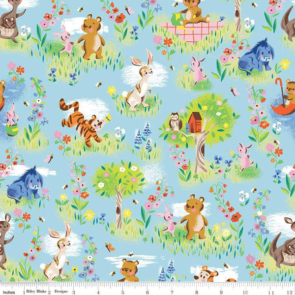 Image of the 100 Aker Woods Main Sky quilting cotton fabric by Jill Howarth for Riley Blake Designs. Features characters from Winnie the Pooh in a forest setting with trees and flowers on a light blue background. 
Cute Little Fabric Shop