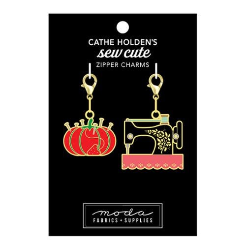 Image of the Sew Cute Zipper Charm pin cushion and sewing machine charms by Cathe Holden for Moda Fabrics. Features a pin cushion and sewing machine enamel charms on lobster clasps. 
Cute Little Fabric Shop