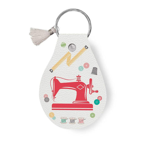 Image of the Leather Circle Key Chain My Happy Place Sewing Machine by Lori Holt for Riley Blake Designs. Features a sewing machine on a full grain leather keychain with tassle. 
Cute Little Fabric Shop