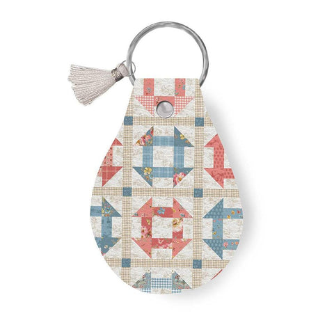 Image of the Leather Circle Key Chain Countryside by Lisa Audit for Riley Blake Designs. Features a quilt square design on a full grain leather keychain with tassel. 
Cute Little Fabric Shop