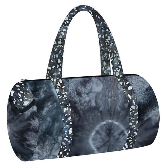 Image of the Melissa Mortenson Saturday Duffle Bag Pattern. Features a round, lined zippered duffle bag with an optional exterior pocket and a detachable shoulder strap. 
Cute Little Fabric Shop