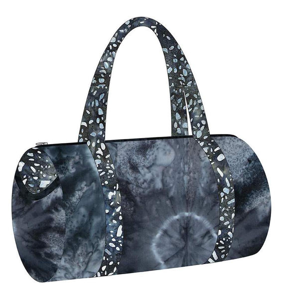 Image of the Melissa Mortenson Saturday Duffle Bag Pattern. Features a round, lined zippered duffle bag with an optional exterior pocket and a detachable shoulder strap. 
Cute Little Fabric Shop