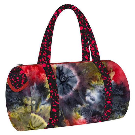 Image of the Melissa Mortenson Saturday Duffle Bag Pattern. Features a round, lined zippered duffle bag with an optional exterior pocket and a detachable shoulder strap. 
Cute Little Fabric Shop