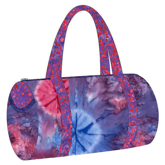 Image of the Melissa Mortenson Saturday Duffle Bag Pattern. Features a round, lined zippered duffle bag with an optional exterior pocket and a detachable shoulder strap. 
Cute Little Fabric Shop