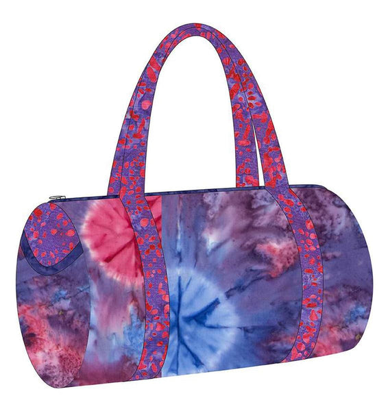 Image of the Melissa Mortenson Saturday Duffle Bag Pattern. Features a round, lined zippered duffle bag with an optional exterior pocket and a detachable shoulder strap. 
Cute Little Fabric Shop