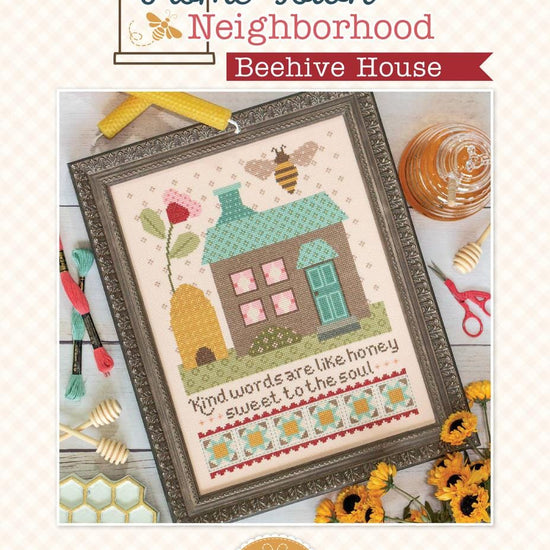 Image of the Home Town Neighbor Beehive House cross stitch pattern  by Lori Holt for Riley Blake Designs. Features a house and a beehive with a flower and bee on a cross stitch pattern. 
Cute Little Fabric Shop