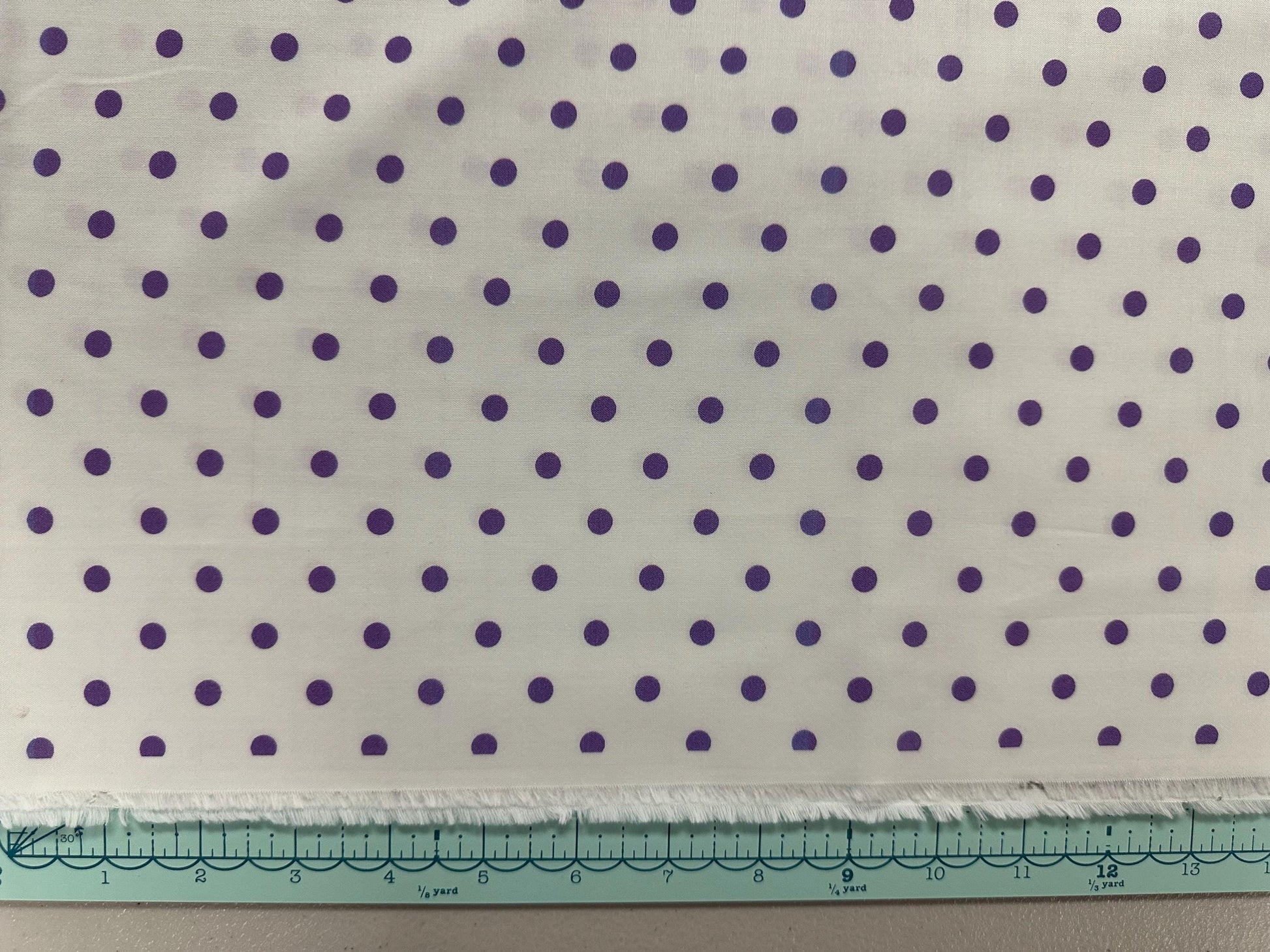 a piece of cloth with purple dots on it