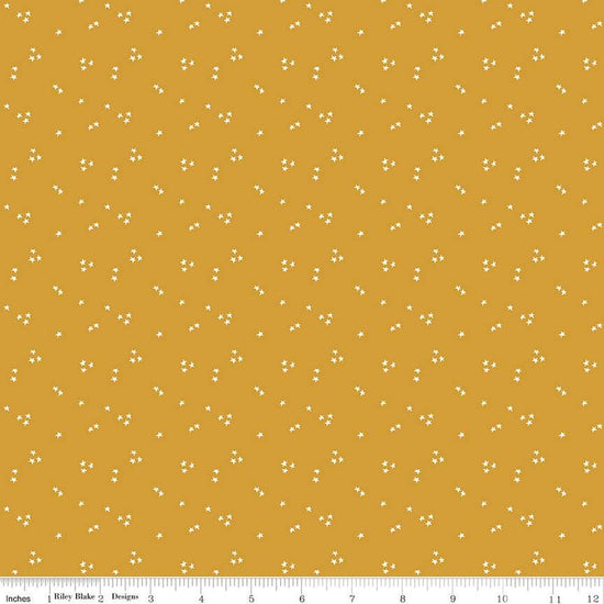 Image of the It Takes a Village Shining Star Honey quilting cotton fabric by Jennifer Long for Riley Blake Designs. Features small scattered stars on a darker yellow background. 
Cute Little Fabric Shop