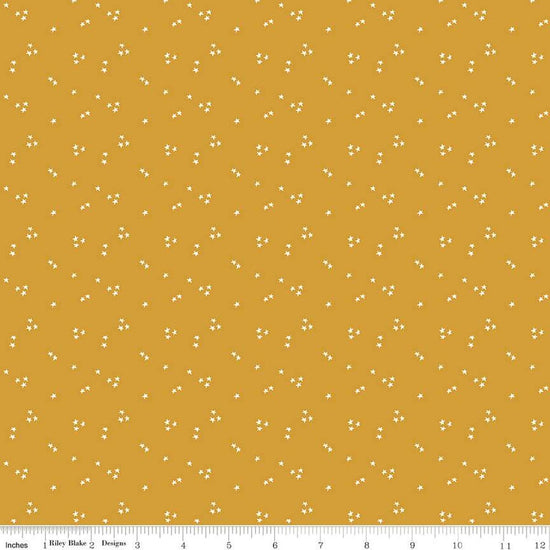 Image of the It Takes a Village Shining Star Honey quilting cotton fabric by Jennifer Long for Riley Blake Designs. Features small scattered stars on a darker yellow background. 
Cute Little Fabric Shop
