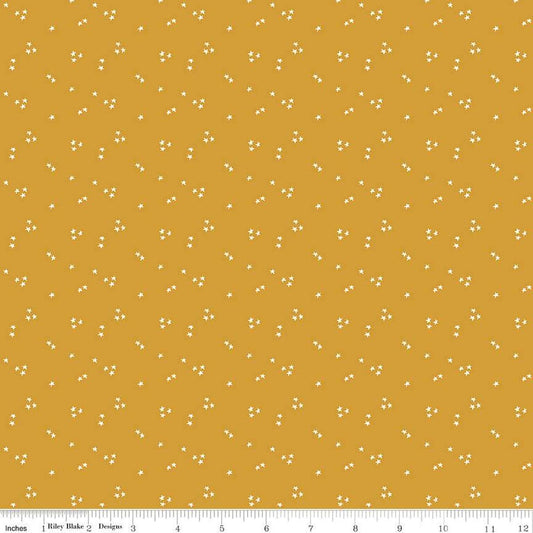 Image of the It Takes a Village Shining Star Honey quilting cotton fabric by Jennifer Long for Riley Blake Designs. Features small scattered stars on a darker yellow background. 
Cute Little Fabric Shop