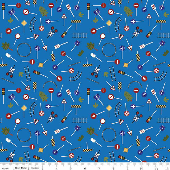 Image of the It Takes a Village Traffic Signs Blue quilting cotton fabric by Jennifer Long for Riley Blake Designs. Features street signs, trees, train tracks, and more on a blue background. 
Cute Little Fabric Shop