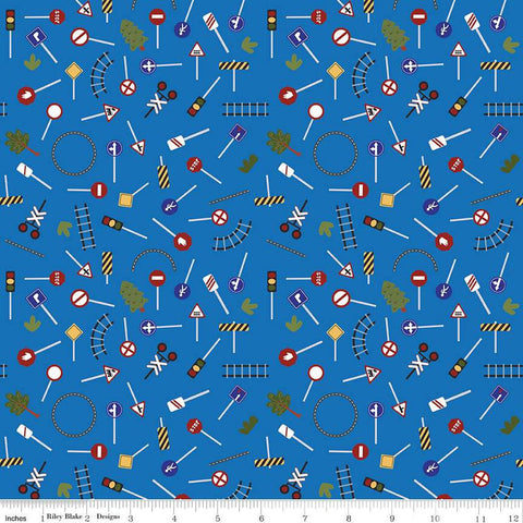 Image of the It Takes a Village Traffic Signs Blue quilting cotton fabric by Jennifer Long for Riley Blake Designs. Features street signs, trees, train tracks, and more on a blue background. 
Cute Little Fabric Shop