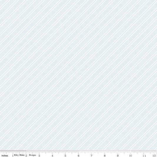Image of the Between the Pages Stripes Iceberg quilting cotton fabric by Fran Gulick for Riley Blake Designs. Features diagonal small stripes on a light blue background. 
Cute Little Fabric Shop