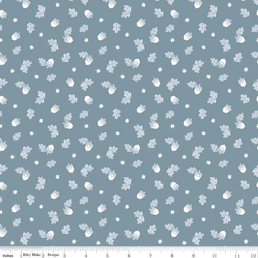 Image of the Twilight Creatures Happy Acorns Storm quilting cotton fabric by Natàlia Juan Abelló for Riley Blake Designs. Features small scattered acorns, stars, and leaves on a gray blue background. 
Cute Little Fabric Shop