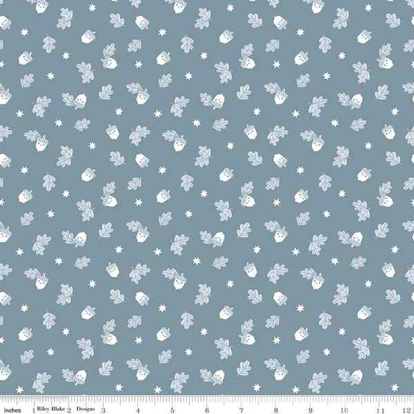 Image of the Twilight Creatures Happy Acorns Storm quilting cotton fabric by Natàlia Juan Abelló for Riley Blake Designs. Features small scattered acorns, stars, and leaves on a gray blue background. 
Cute Little Fabric Shop