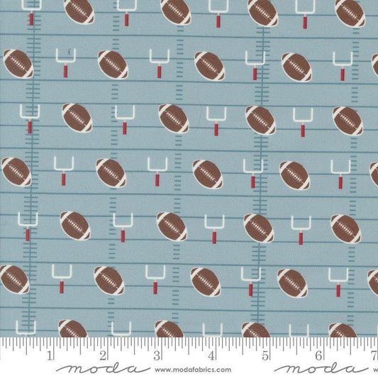 Image of the Play Ball Football Dolphin quilting cotton fabric by Moda Fabrics. Features novelty goal posts and footballs on a blue background. 
Cute Little Fabric Shop