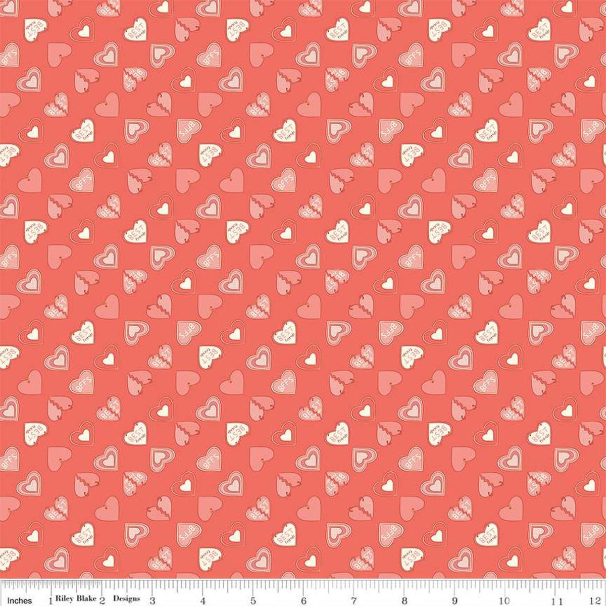 Image of the Besties Charms Lipstick quilting cotton fabric by Corinne Wells for Riley Blake Designs. Features hearts on a coral background. Cute Little Fabric Shop