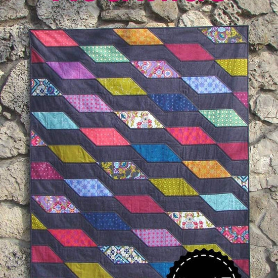 Image of the Rockslide quilt pattern by Slice of Pi Quilts by Riley Blake Designs. Features diamond shapes on a quilt. 
Cute Little Fabric Shop