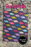 Image of the Rockslide quilt pattern by Slice of Pi Quilts by Riley Blake Designs. Features diamond shapes on a quilt. 
Cute Little Fabric Shop