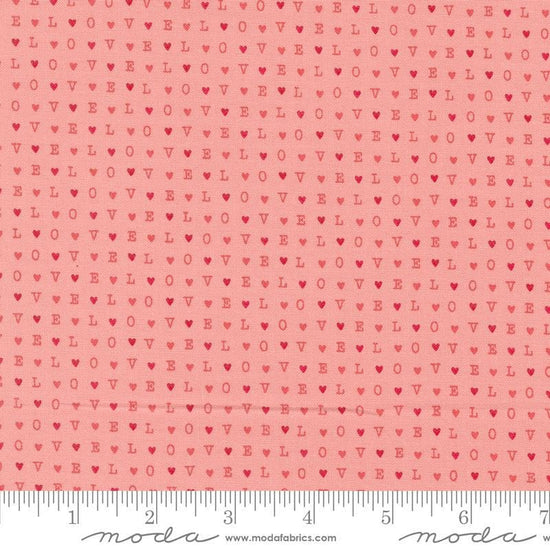 Image of the Love Blooms LOVE Blush quilting cotton fabric by Moda Fabrics. Features the word LOVE on a pink background. Cute Little Fabric Shop
