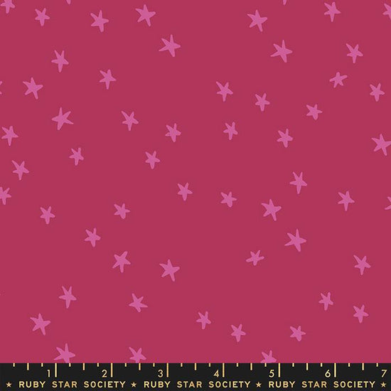 Image of the Starry Blenders Star Plum quilting cotton fabric by Alexia Abegg for Moda Fabrics. Features small scattered stars on a dark pink background. Cute Little Fabric Shop