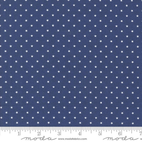 Image of the Star Spangled Twinkle Twilight quilting cotton fabric by Moda Fabrics. Features stars on a blue background. Cute Little Fabric Shop