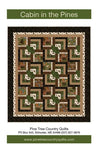 Image of the Cabin in the Pines quilt pattern by Pine Tree Country Quilts for Riley Blake Designs. Features a striped brown quilt. Cute Little Fabric Shop