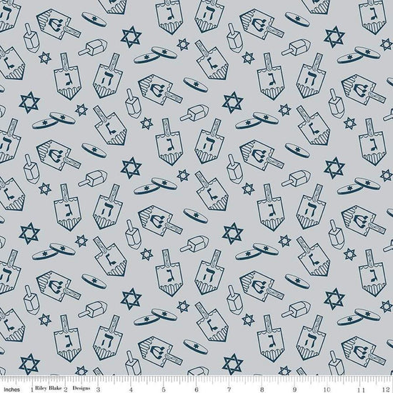 Image of the 8 Nights, 8 Lights Dreidel Toss Silver quilting cotton fabric by Riley Blake Designs. Features dreidels on a gray background. Cute Little Fabric Shop