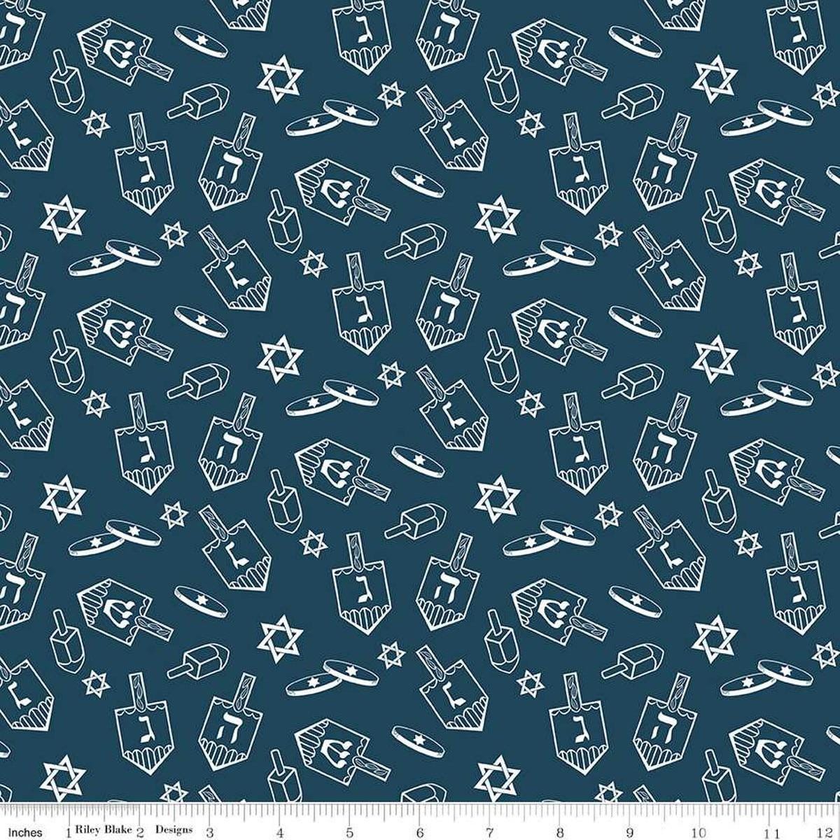 Image of the 8 Nights, 8 Lights Dreidel Toss Navy quilting cotton fabric by Riley Blake Designs. Features dreidels on a blue background. Cute Little Fabric Shop
