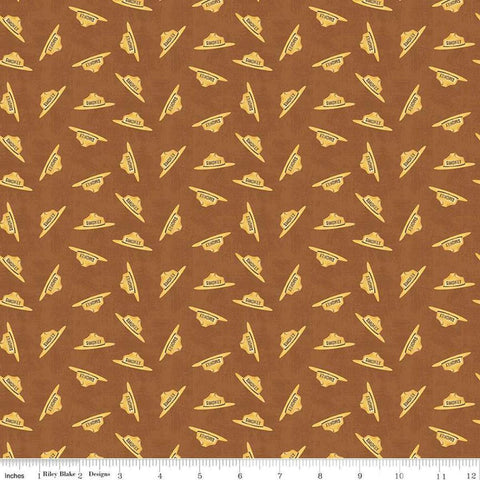 Image of the Friends of Smokey Bear Hat Toss Sienna quilting cotton fabric. Features hats on a brown background. Cute Little Fabric Shop