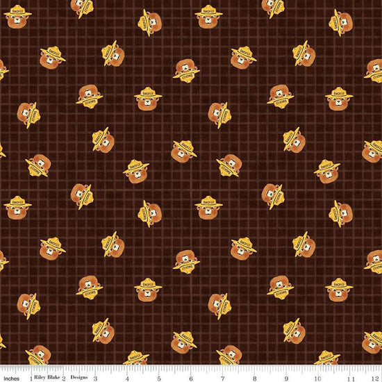 Image of the Friends of Smokey Bear Head Toss Bark quilting cotton fabric. Features smokey heads on a green background. Cute Little Fabric Shop