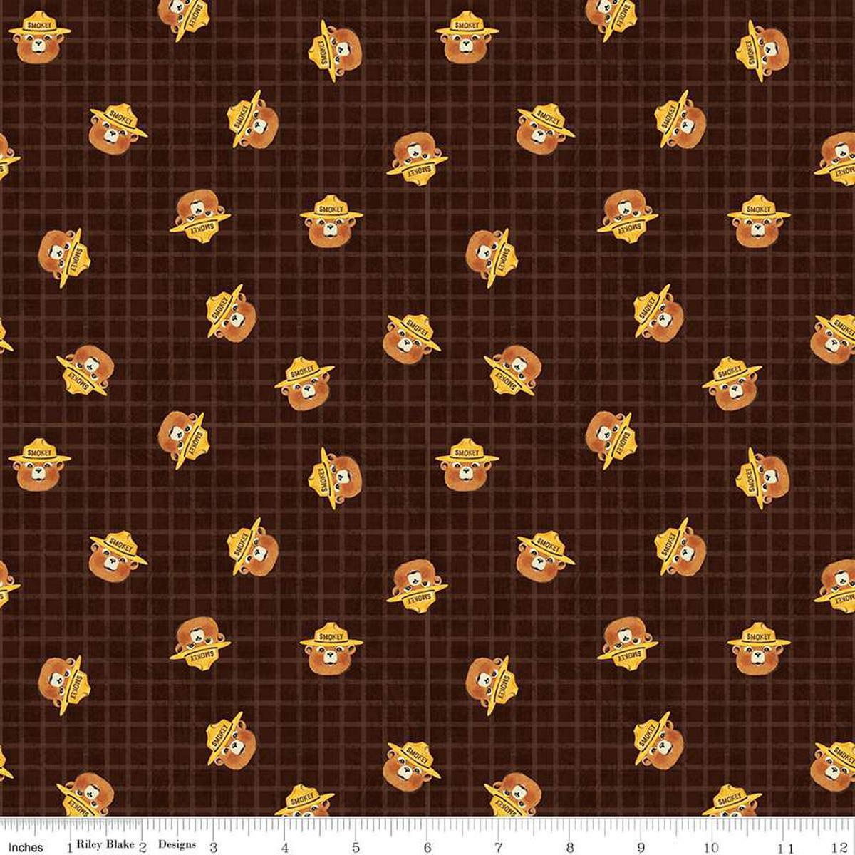 Image of the Friends of Smokey Bear Head Toss Bark quilting cotton fabric. Features smokey heads on a green background. Cute Little Fabric Shop