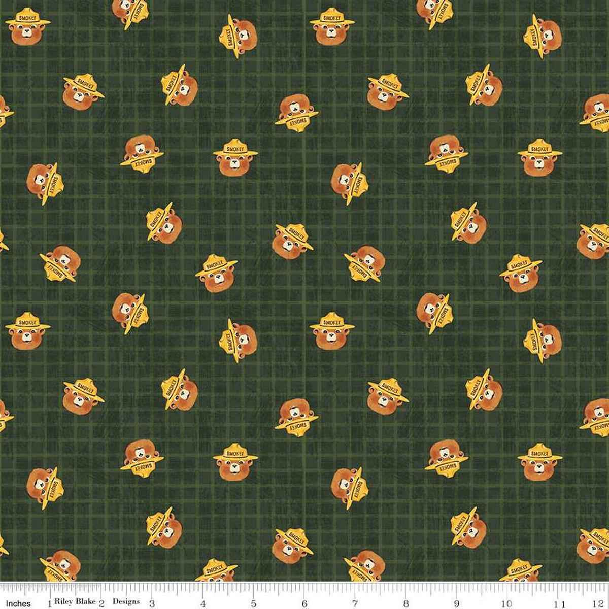 Image of the Friends of Smokey Bear Head Toss Forest quilting cotton fabric. Features smokey heads on a green background. Cute Little Fabric Shop