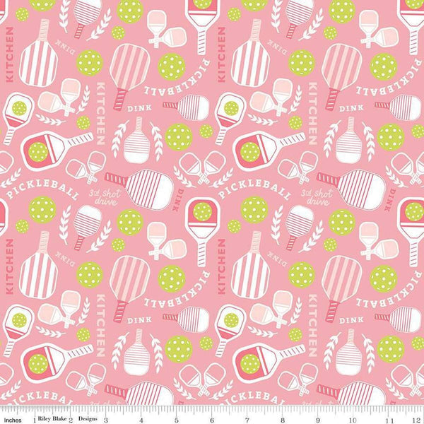 Image of the Pickleball Main Pink quilting cotton fabric by Riley Blake Designs. Features pickleball items on a pink background. Cute Little Fabric Shop