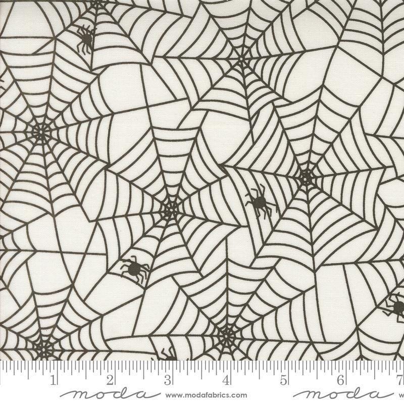 Image of the Fab Boo Lous Webs Ghostly quilting cotton fabric. Features spiderwebs on a cream background. Cute Little Fabric Shop