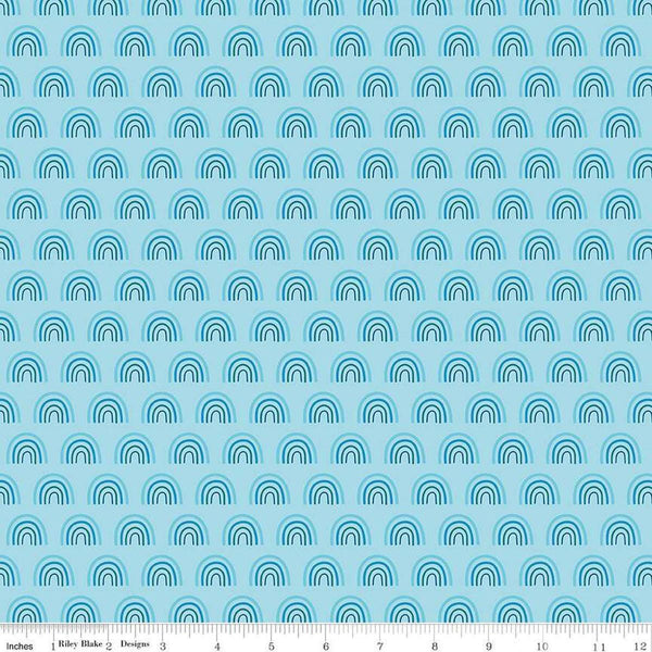 Image of the Two by Two Chasing Rainbows Sky quilting cotton fabric by Cayla Naylor for Riley Blake Designs. Features rainbows on a blue background. Cute Little Fabric Shop