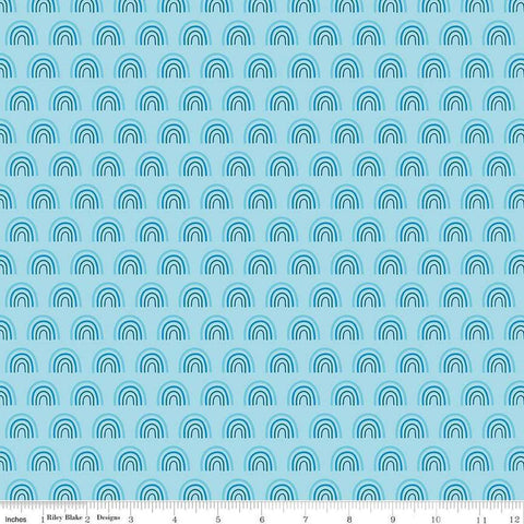 Image of the Two by Two Chasing Rainbows Sky quilting cotton fabric by Cayla Naylor for Riley Blake Designs. Features rainbows on a blue background. Cute Little Fabric Shop