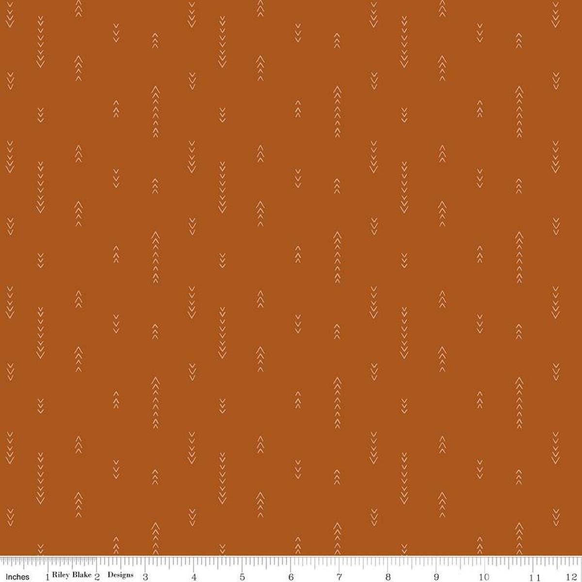 Image of Olive Grove Arrows Terracotta quilting cotton fabric by Amber Elliot for Riley Blake Designs. Features arrows on an orange background. Cute Little Fabric Shop