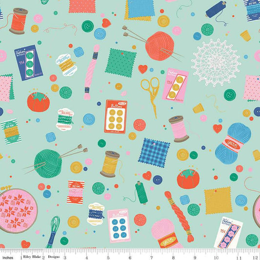 Image of Hand Made Notions Mint quilting cotton fabric by Amber Kemp-Gerstel for Riley Blake Designs. Features sewing supplies on a green background. Cute Little Fabric Shop