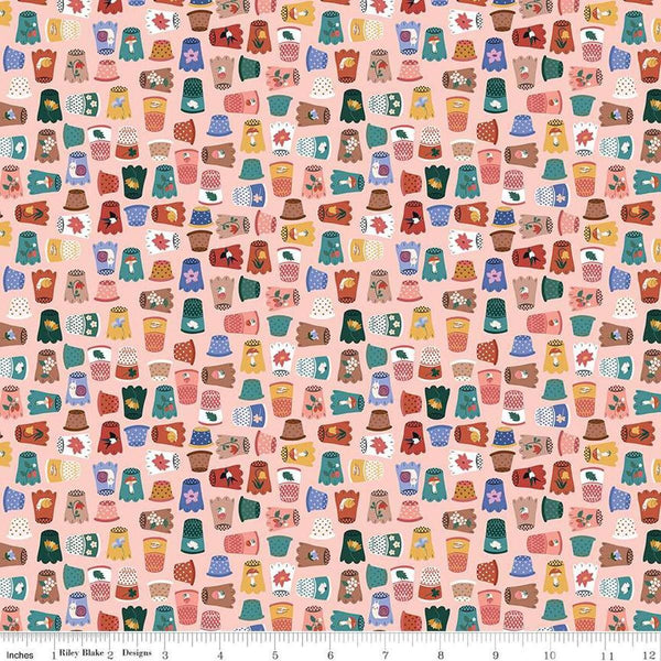 Image of Thimbelina & The Sewing Fairies Thimble Collection Apricot Mist quilting cotton fabric by Jennifer Long for Riley Blake Designs. Features thimbles on a pink background. Cute Little Fabric Shop